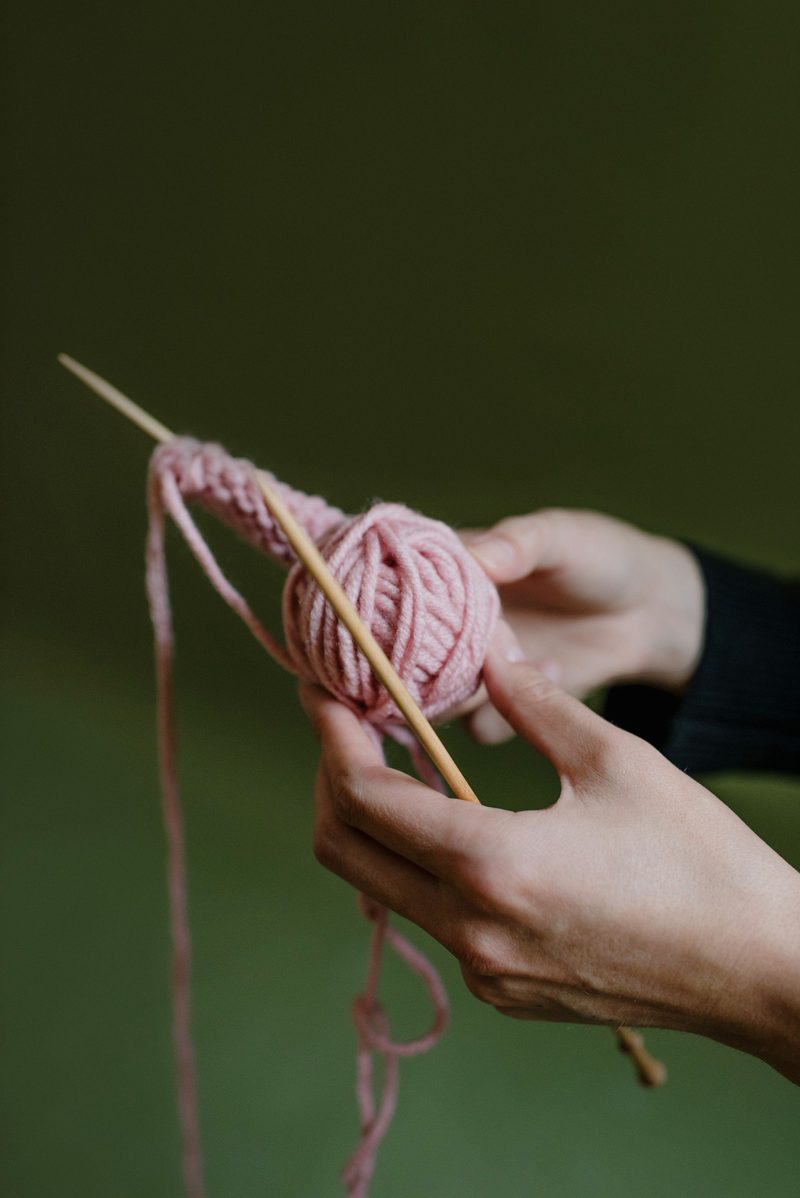 Hands winding pink yarn