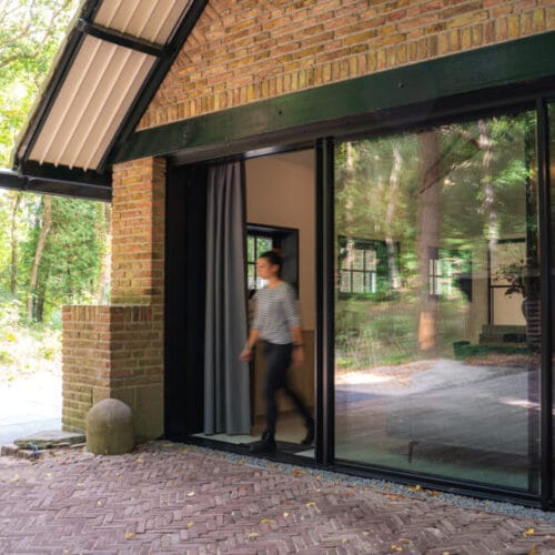 Glass doors at the entrance of Blooming, a former school in the woods near Bergen