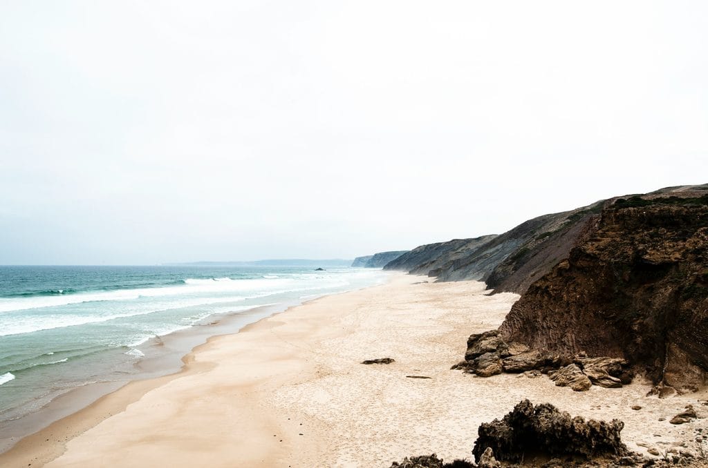 Empty sand and dark cliffs at Praia da Bordeira, western Algarve