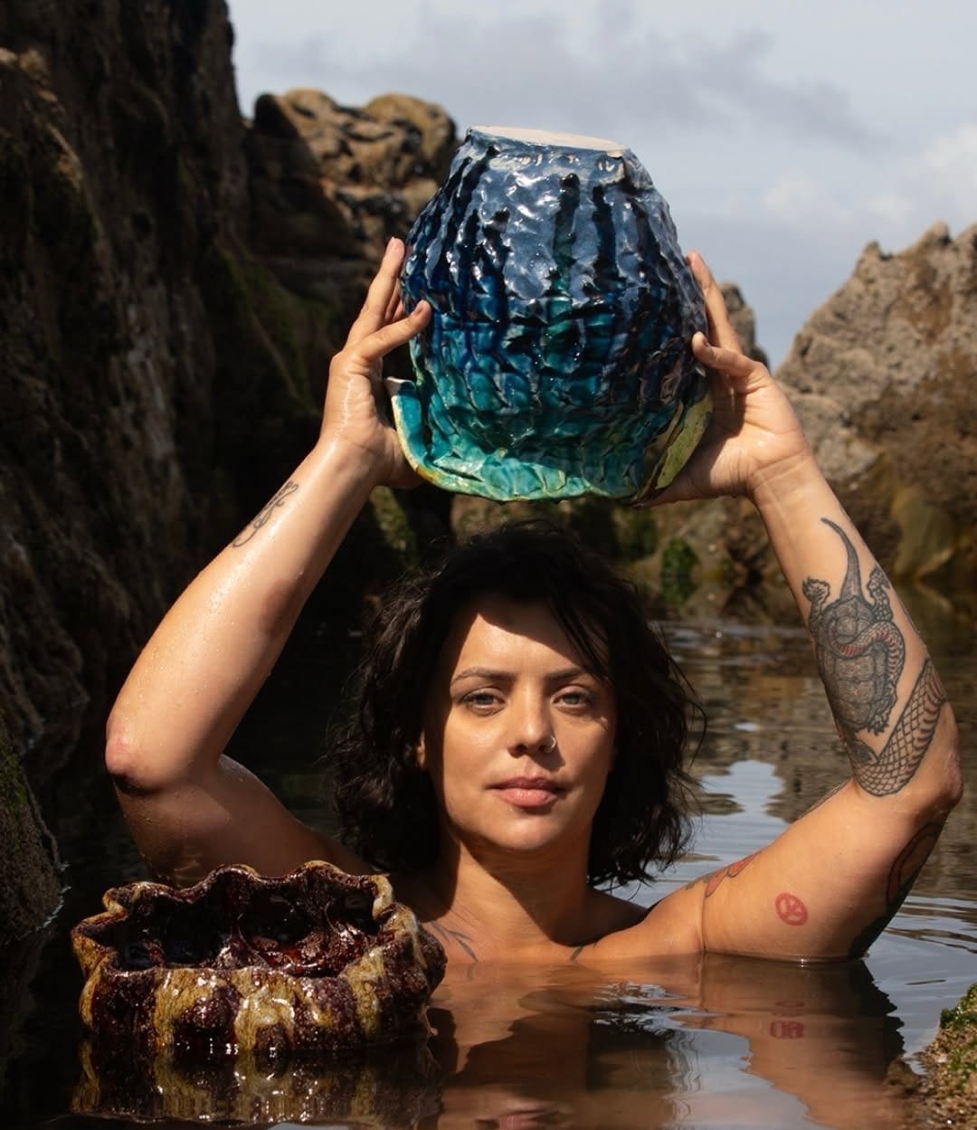 Clara Rêgo holding one of her hand-built ceramic vessels on the Portuguese coast