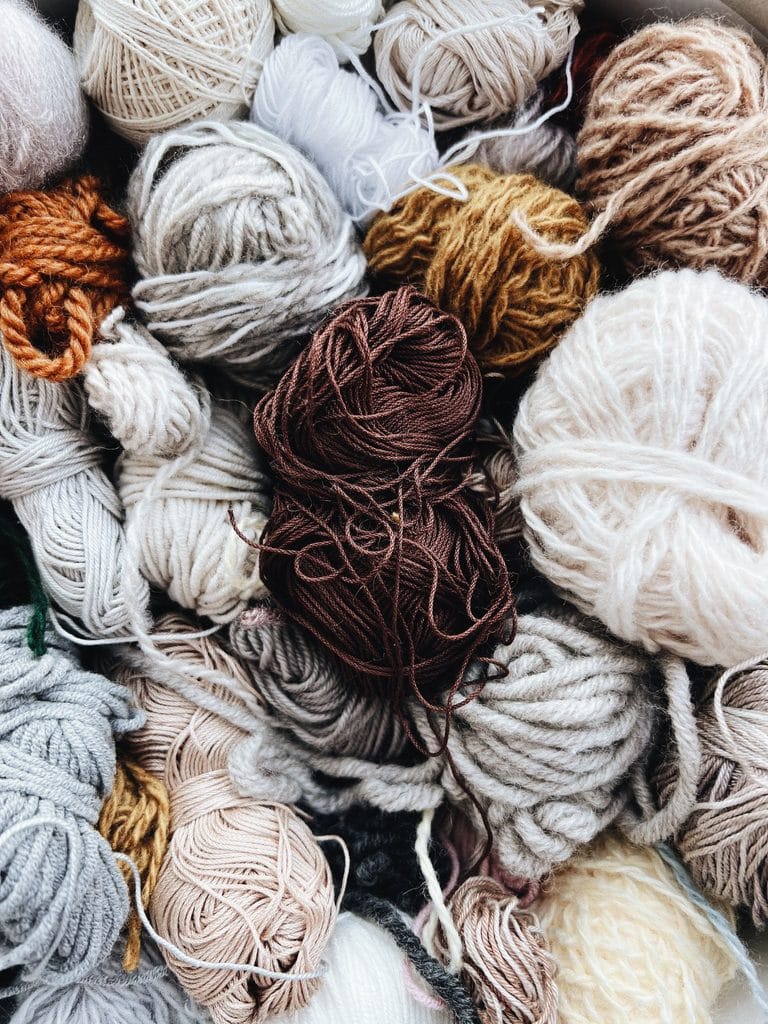 Pile of wool skeins in cream, gray, brown and blue